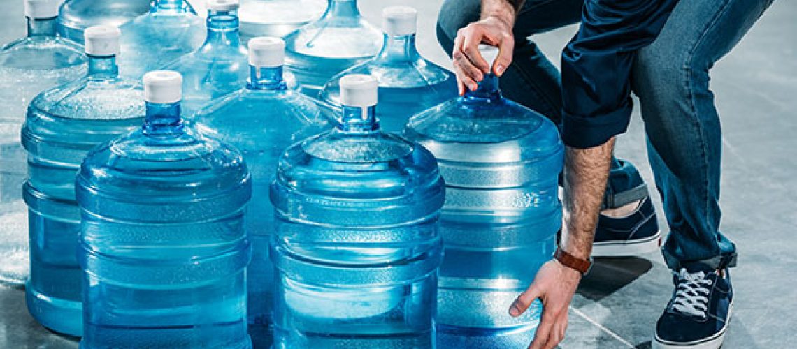 Man-delivering-large-bottles-with-drinking-water.jpeg