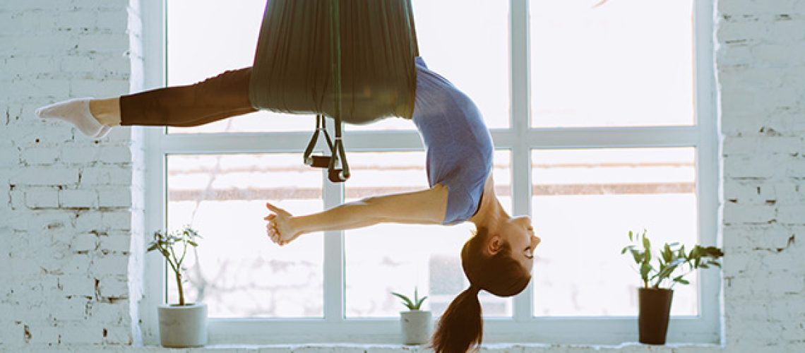 Young-woman-doing-aerial-fly-yoga-and-stretches.jpg
